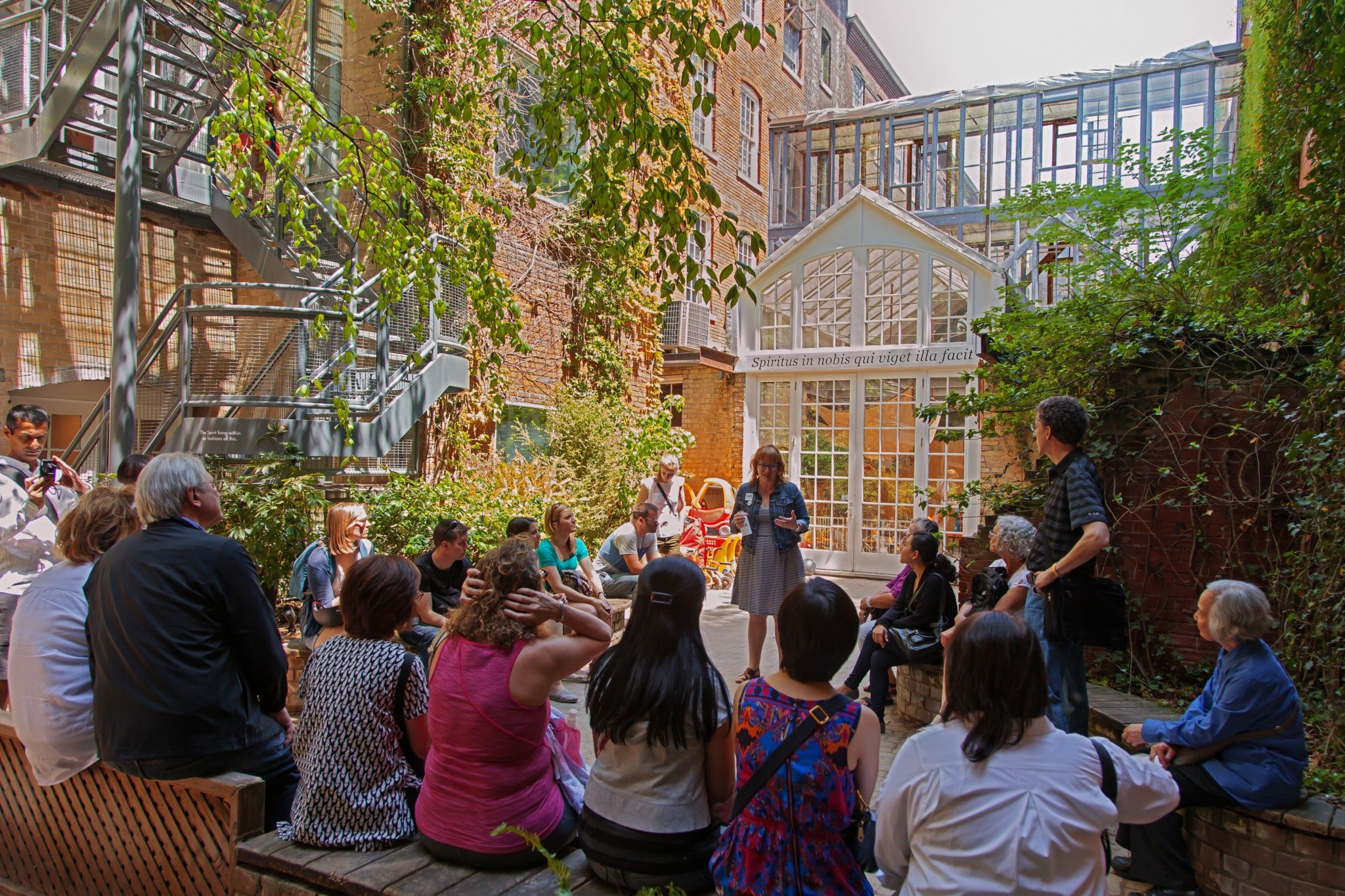 This image features a gathering in the central courtyard garden of 401 Richmond, a historic brick-and-beam industrial building in Toronto's Fashion District.