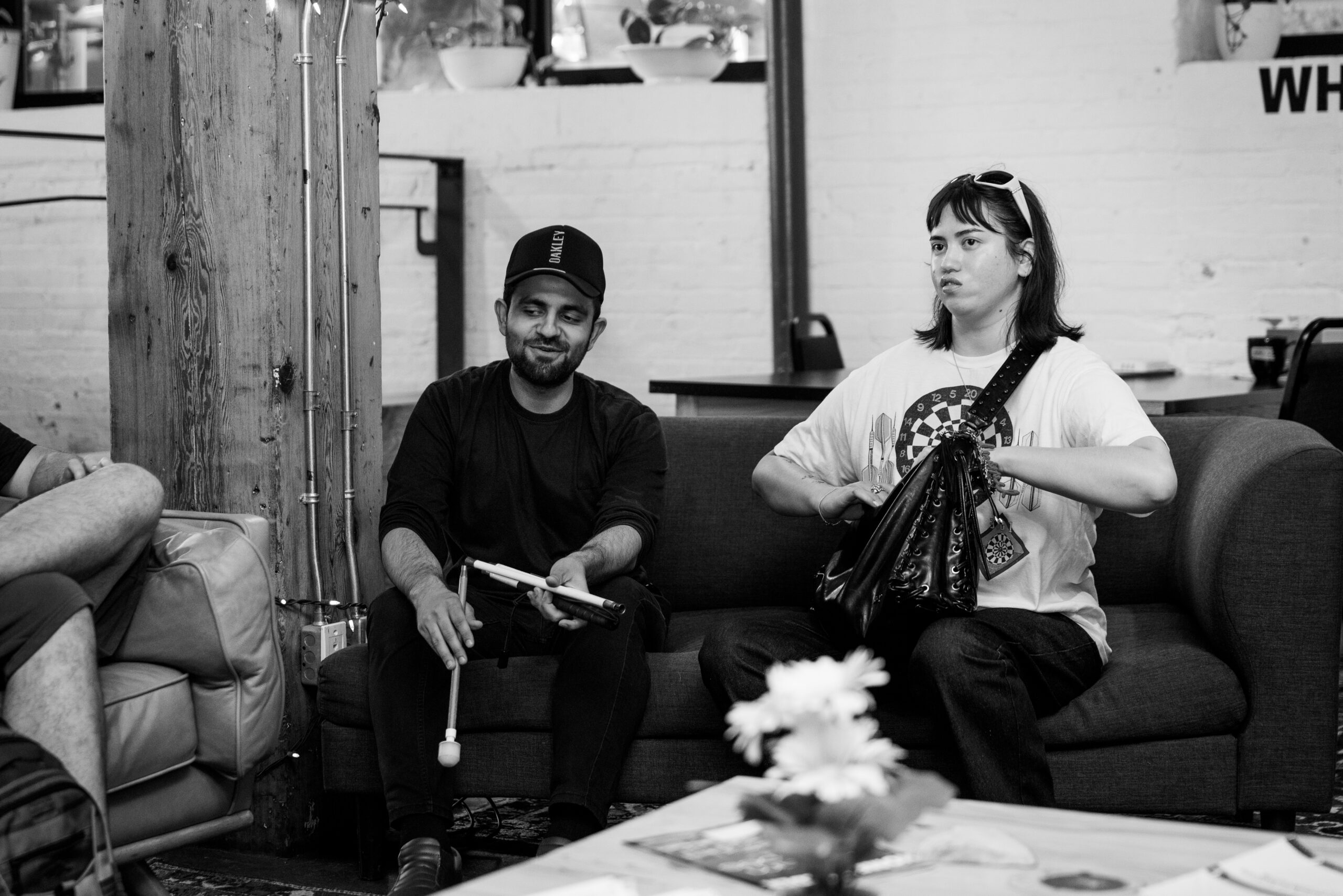 black and white photo of two members from the FUTURES program, seated on a sofa together.